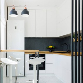 Avental preto em uma cozinha branca