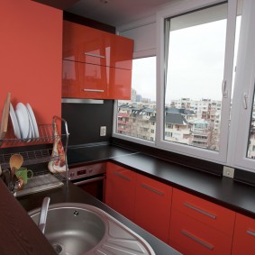 Sarkanā un melnā virtuve uz pievienotā balkona