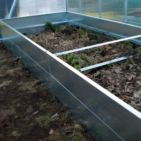 Galvanized wall of a raised bed in a greenhouse in the country