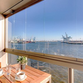 Warm beglaasd balkon met uitzicht op de haven