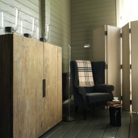 Gestoffeerde fauteuil in een kamer van een huis gemaakt van hout