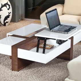 bärbar dator på ett transformerande bord i ett vardagsrum