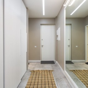 En enorm spegel i korridoren i en lägenhet med två sovrum