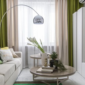 To farger gardiner i stuen til en leilighet med to soverom