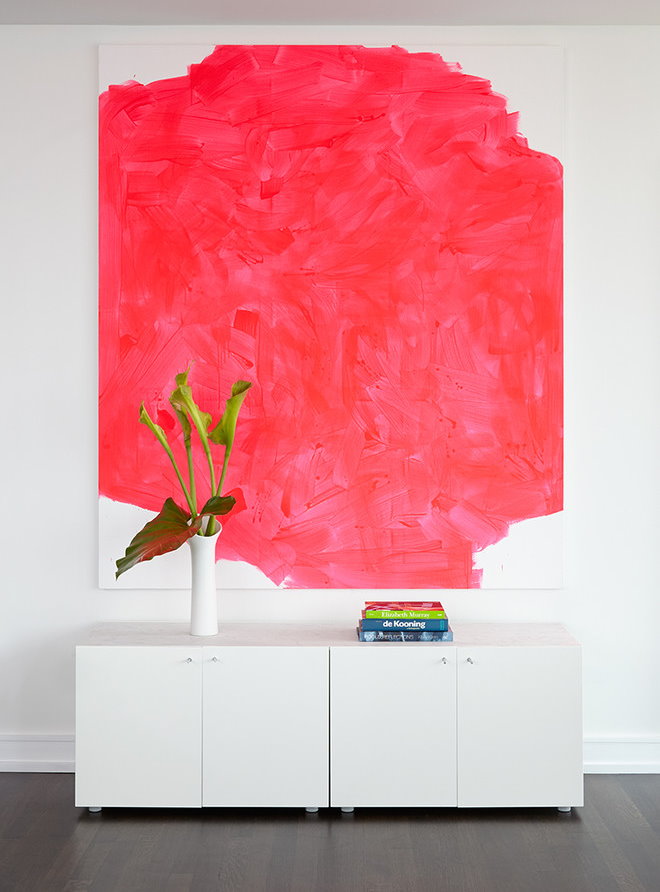 Červená abstrakcia na bielej stene obývacej izby