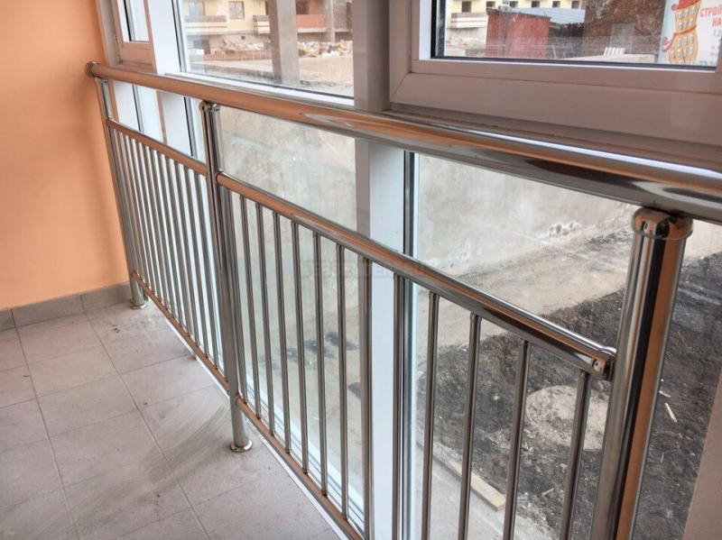 Stainless steel railing on the balcony with plastic windows
