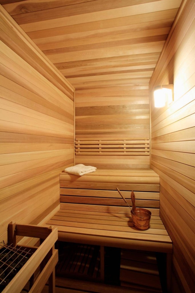 Ang mga istante sa isang makitid na silid ng singaw ng isang compact sauna