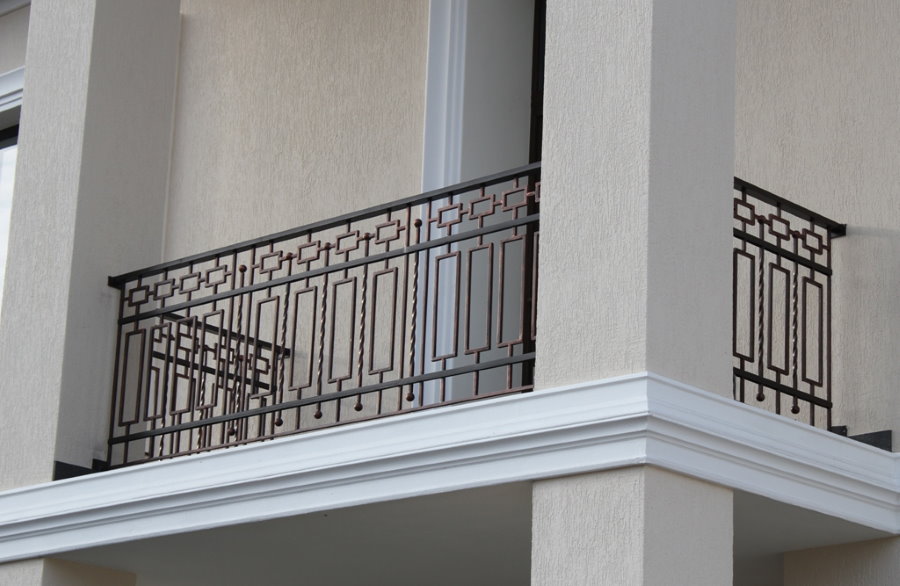 Straight painted steel railing between columns on the loggia