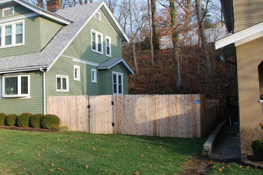 Gard din lemn între casele vecine